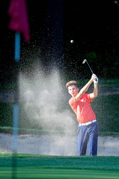 Joven jugador de golf golpeando pelota por madera durante la competición
  - Foto, imagen