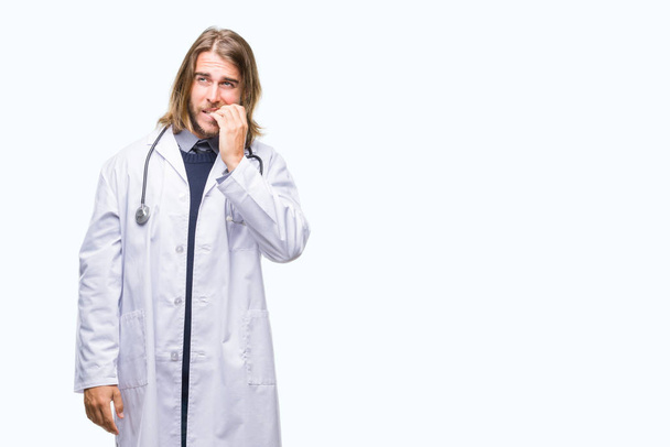 Young handsome doctor man with long hair over isolated background looking stressed and nervous with hands on mouth biting nails. Anxiety problem. - Photo, Image