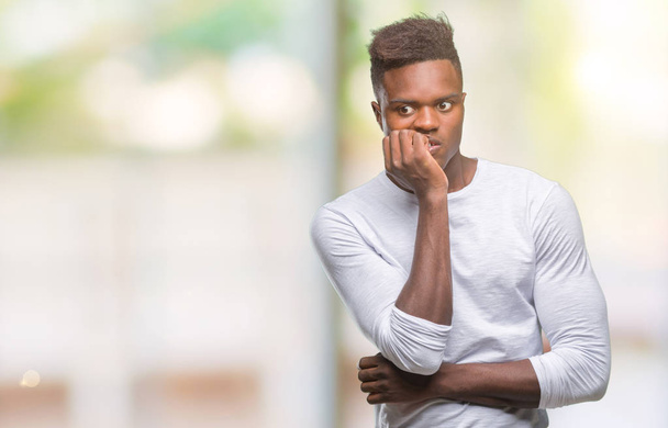 Young african american man over isolated background looking stressed and nervous with hands on mouth biting nails. Anxiety problem. - Фото, изображение