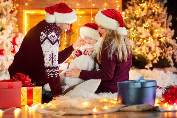Happy family with a baby in a Christmas room. - Foto, Bild