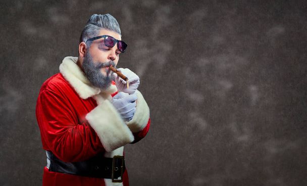 Santa Claus with a fashion hairdress smokes a cigar. - Fotografie, Obrázek