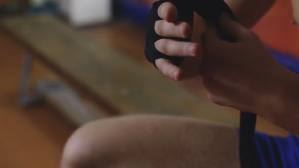 Nuori nyrkkeilijä käärimistä siteet kätensä ennen taistelua
 - Materiaali, video