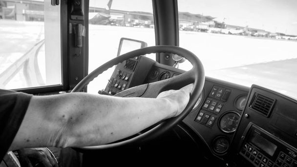 Musta ja valkoinen kuva matkustajabussista lentokentän kiitoradalla
 - Valokuva, kuva