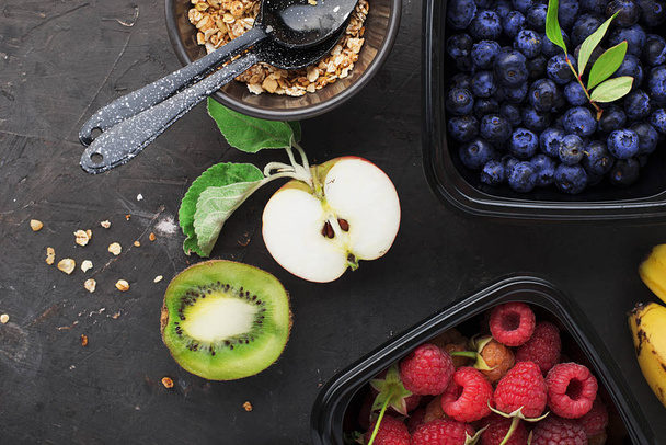 Ingredients for healthy breakfast meals: raspberries, blueberries, nuts, orange, bananas, grapes blue, green apples kiwi Top View - Foto, imagen