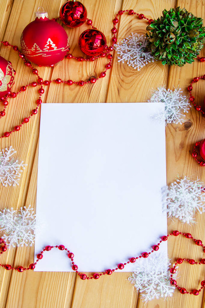 Το παιδί γράφει ένα γράμμα στον Αϊ-Βασίλη στον πίνακα μεταξύ το χριστουγεννιάτικο δέντρο διακοσμήσεις. Θέα από ψηλά. - Φωτογραφία, εικόνα