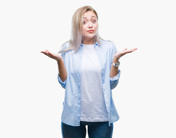 Young blonde woman over isolated background clueless and confused expression with arms and hands raised. Doubt concept. - Foto, Bild