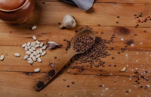 Kidney beans, garlic, and lentils on a wooden table. - Fotoğraf, Görsel