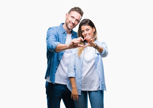 Young couple in love over isolated background smiling in love showing heart symbol and shape with hands. Romantic concept. - Foto, immagini