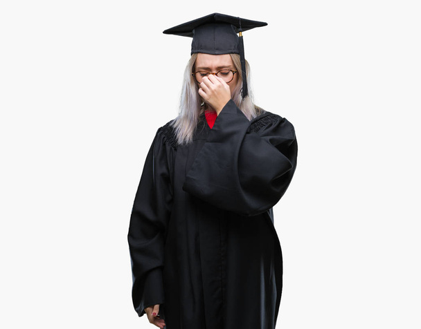 Jeune femme blonde portant un uniforme diplômé sur fond isolé fatigué se frottant le nez et les yeux ressentant fatigue et maux de tête. Concept de stress et de frustration
. - Photo, image
