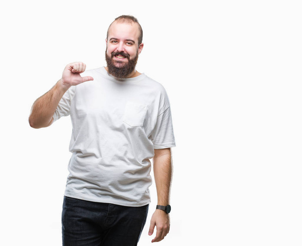 Joven hombre hipster caucásico con camiseta casual sobre fondo aislado mirando confiado con sonrisa en la cara, señalándose con los dedos orgullosos y felices
. - Foto, imagen