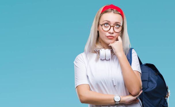 Young blonde student woman wearing glasses and backpack over isolated background with hand on chin thinking about question, pensive expression. Smiling with thoughtful face. Doubt concept. - Foto, immagini