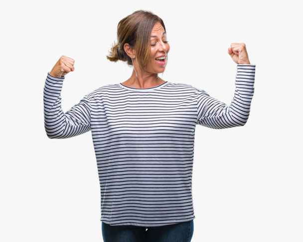 Middle age senior hispanic woman over isolated background showing arms muscles smiling proud. Fitness concept. - Fotoğraf, Görsel