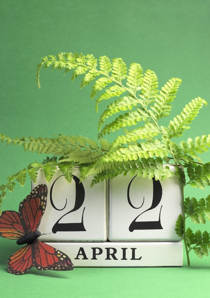 Dia da Terra, salve a data calendário bloco branco, 22 de abril, com borboleta e samambaias contra um fundo verde. Vertical com espaço de cópia
. - Foto, Imagem