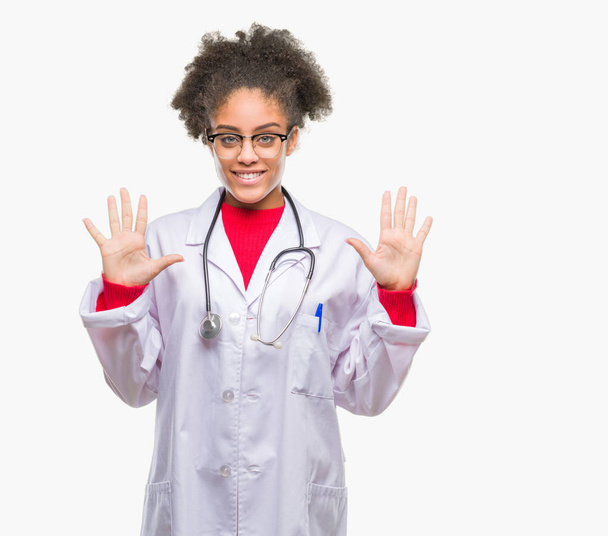 Jonge afro Amerikaanse dokter vrouw over geïsoleerde achtergrond weergeven en met de vingers omhoog nummer tien terwijl lacht zelfverzekerd en blij. - Foto, afbeelding