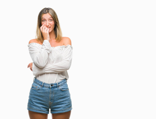 Young beautiful woman over isolated background looking stressed and nervous with hands on mouth biting nails. Anxiety problem. - Photo, Image