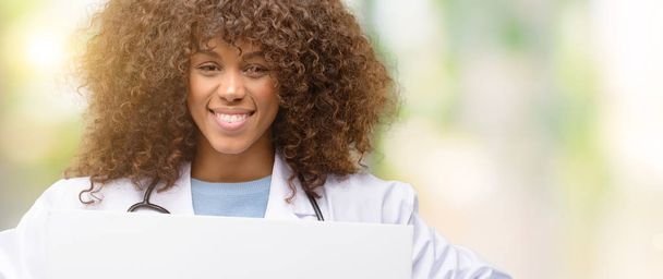 Nő afro-amerikai orvos, egészségügyi szakember dolgozik a gazdaság üres reklám banner, jó poszter ad, ajánlatot vagy bejelentés, nagy papír billboard - Fotó, kép