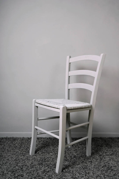 empty vacant chair in entirely gray room - Foto, Imagen