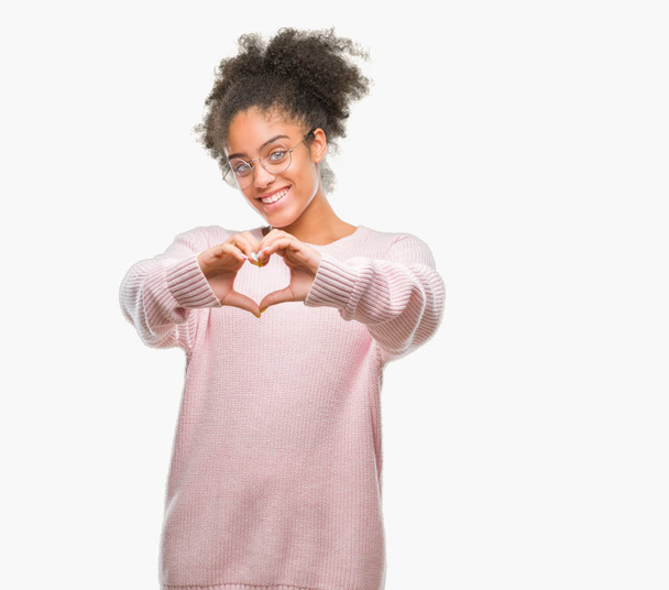 Молодих афро американська жінка в окулярах над ізольованих фону, посміхаючись в любові, показуючи серце символ і форма руками. Романтичної концепції. - Фото, зображення