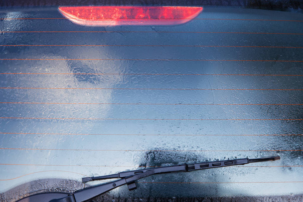 車の後部窓の凍結が氷で覆われています。 - 写真・画像