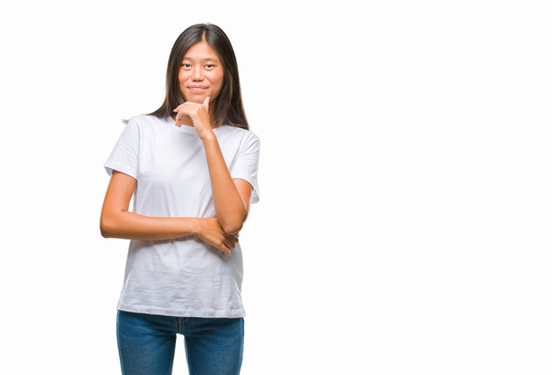 Giovane donna asiatica su sfondo isolato guardando fiducioso la fotocamera con sorriso a braccia incrociate e mano alzata sul mento. Pensare positivo
. - Foto, immagini