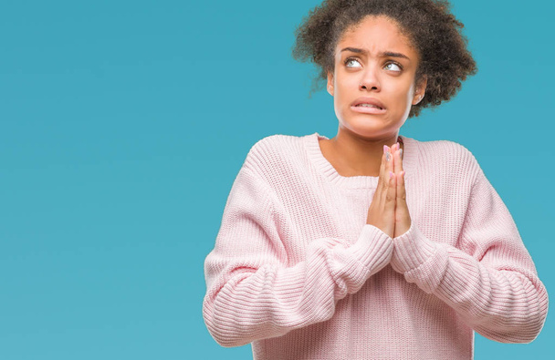 Молодая афро-американка в зимнем свитере на изолированном фоне просит и молится руками вместе с выражением надежды на лице очень эмоциональным и обеспокоенным. Просил прощения. Концепция религии
. - Фото, изображение