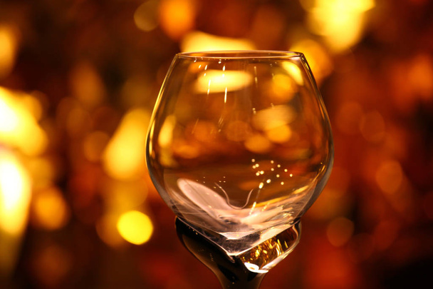 empty glass cognac gold bokeh studio - Foto, imagen