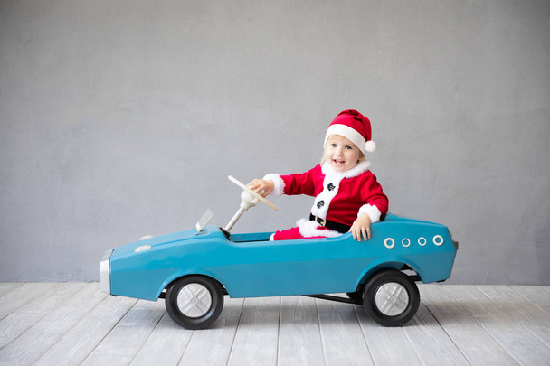 Happy child paying at home. Kid having fun on Christmas time. Xmas holiday concept - Photo, image