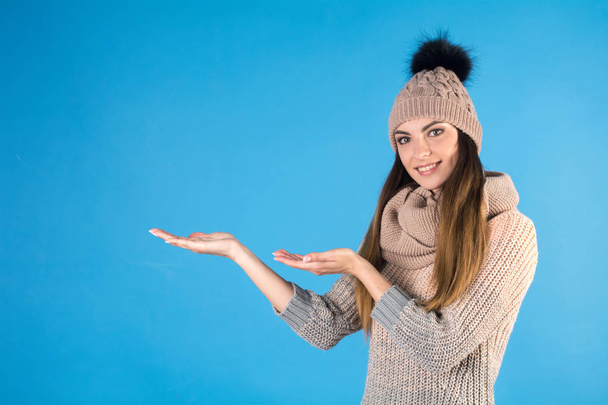 Girl in a warm sweater, scarf and hat on a blue background - Photo, Image