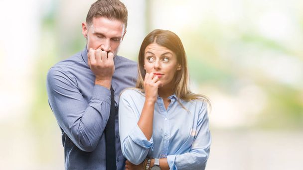 Young workers business couple over isolated background looking stressed and nervous with hands on mouth biting nails. Anxiety problem. - Photo, Image