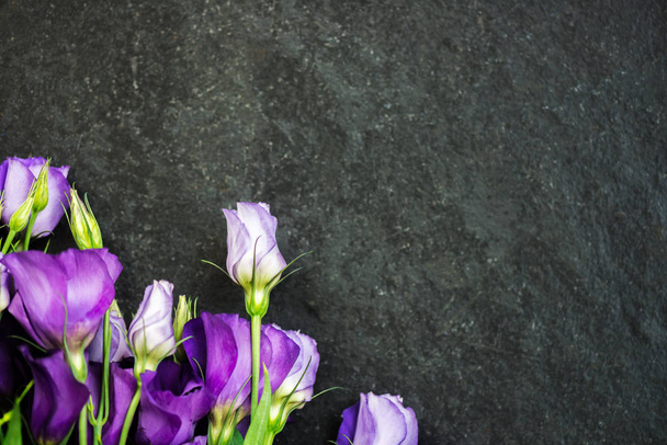 Belo buquê de flores de Eustoma roxo, Lisianthus, fundo cinza escuro. Vista superior, espaço de cópia, flat lay
 - Foto, Imagem