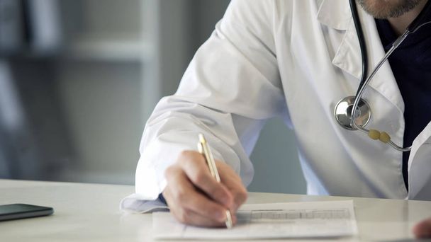 Experienced physician completing health insurance claim form, healthcare - Zdjęcie, obraz