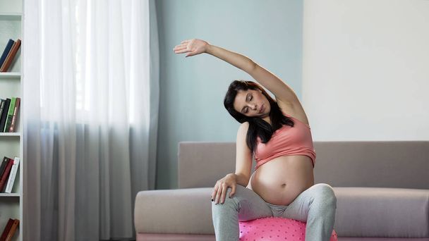 Woman doing yoga during pregnancy to improve circulation and tone muscles - Фото, изображение