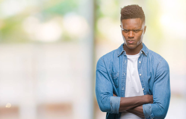 Giovane uomo afroamericano su sfondo isolato scettico e nervoso, espressione di disapprovazione sul viso con le braccia incrociate. Persona negativa
. - Foto, immagini