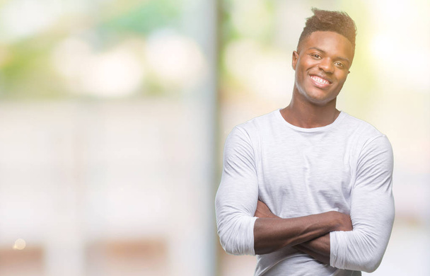 Jeune homme afro-américain sur fond isolé heureux visage souriant avec les bras croisés regardant la caméra. Personne positive
. - Photo, image