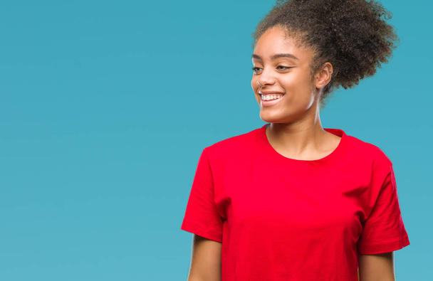 Young afro american woman over isolated background looking away to side with smile on face, natural expression. Laughing confident. - Zdjęcie, obraz