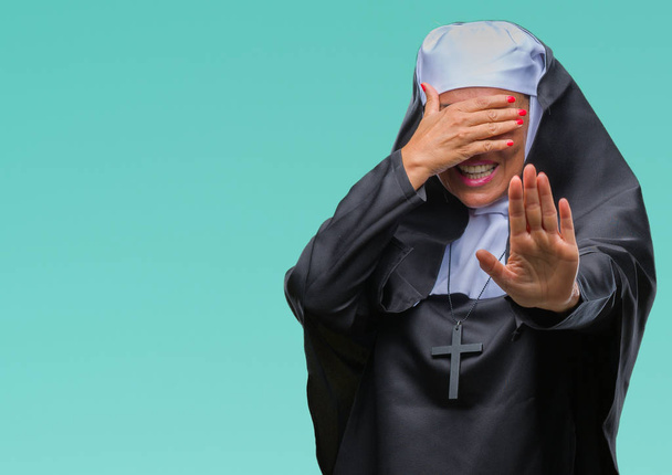 Orta yaş üst düzey Hıristiyan Katolik Rahibe kadın izole elleriyle gözlerini kapsayan arka plan ve stop jest ile acı ve korku ifadesi. Utandım ve negatif kavramı. - Fotoğraf, Görsel