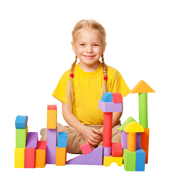 Happy little girl constructing houses from color toy blocks. - Foto, Imagem