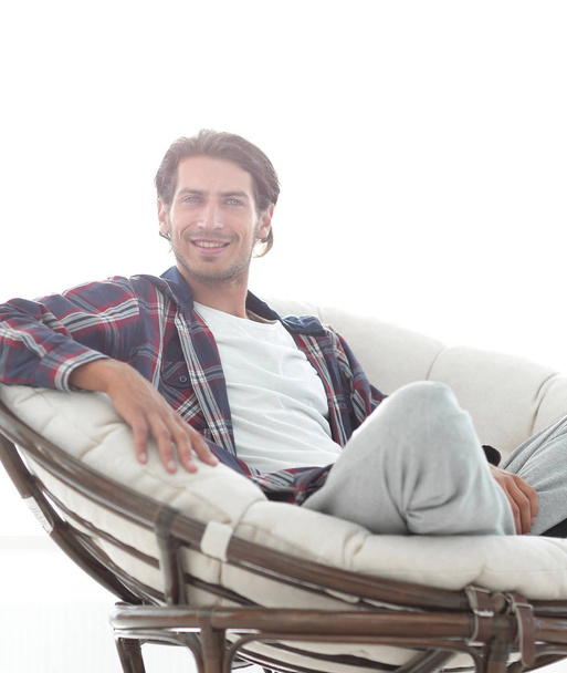 close-up of a smiling guy stroking his dog while sitting in a large armchair. - Foto, immagini