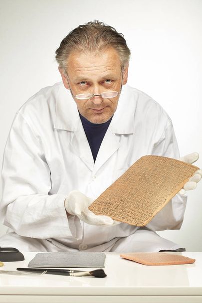 Scientist holding ancient type of Akkad empire style cuneiform  - Fotó, kép