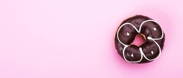 Смачний пончик з шоколадом ізольований на рожевому фоні. Простір для перегляду згори
 - Фото, зображення