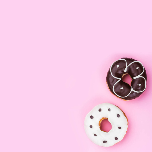 Вкусные глазированные пончики на цветном фоне. Вкусный десерт, вид сверху
 - Фото, изображение