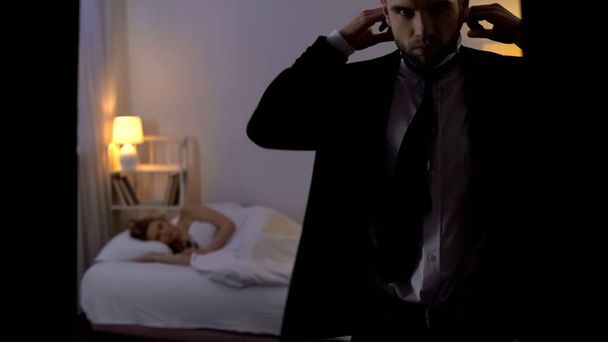 Self-confident man wearing business suit, seduced lady sleeping in bed, pickup - Photo, image