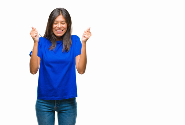 Young asian woman over isolated background excited for success with arms raised celebrating victory smiling. Winner concept. - Fotoğraf, Görsel
