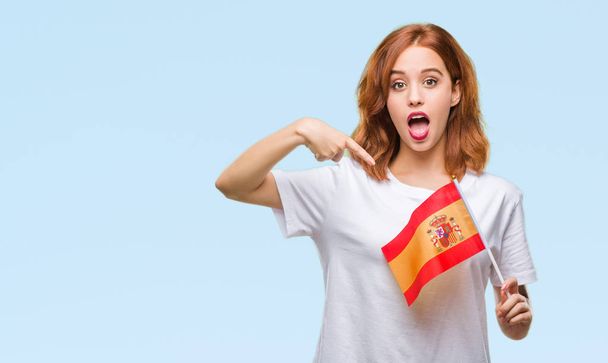 Young beautiful woman holding flag of spain over isolated background very happy pointing with hand and finger - Fotoğraf, Görsel