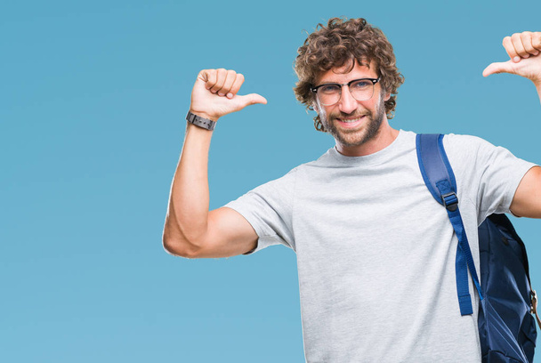 Jóképű spanyol diák ember visel a hátizsák és a szemüveg alatt elszigetelt háttér látszó magabiztos mosollyal arcán, mutatva magát, ujjaival, büszke és boldog. - Fotó, kép