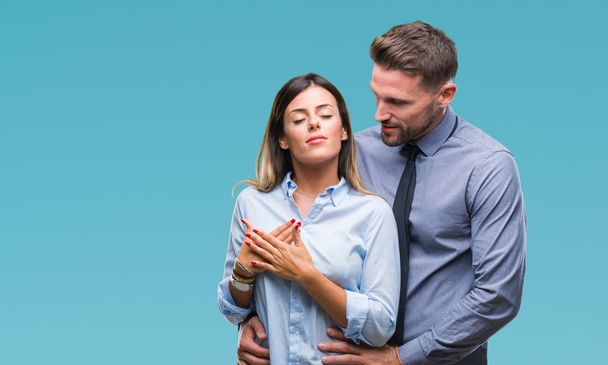Young workers business couple over isolated background smiling with hands on chest with closed eyes and grateful gesture on face. Health concept. - Photo, Image