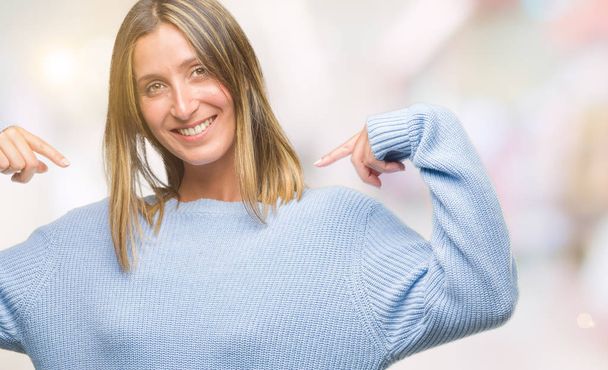Mujer hermosa joven vistiendo suéter de invierno sobre fondo aislado mirando confiado con sonrisa en la cara, señalándose con los dedos orgullosos y felices
. - Foto, imagen