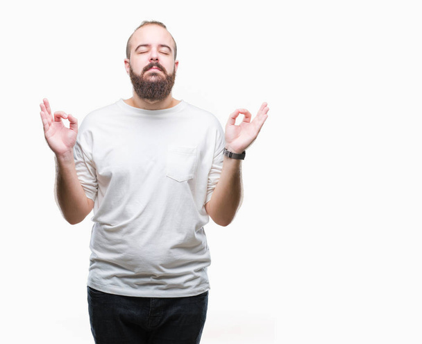 Mladý bělošský bokovky muž nosí ležérní tričko izolované pozadí relaxovat a usmívající se očima uzavřené vede meditační gesta prsty. Koncept jógy. - Fotografie, Obrázek