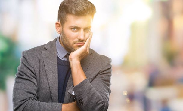 Young handsome business man over isolated background thinking looking tired and bored with depression problems with crossed arms. - Photo, Image