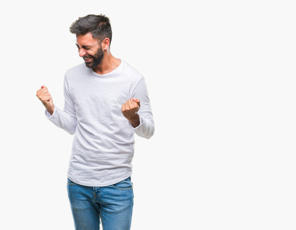 Homme hispanique adulte sur fond isolé très heureux et excité de faire geste gagnant avec les bras levés, souriant et criant pour le succès. Concept de célébration
. - Photo, image